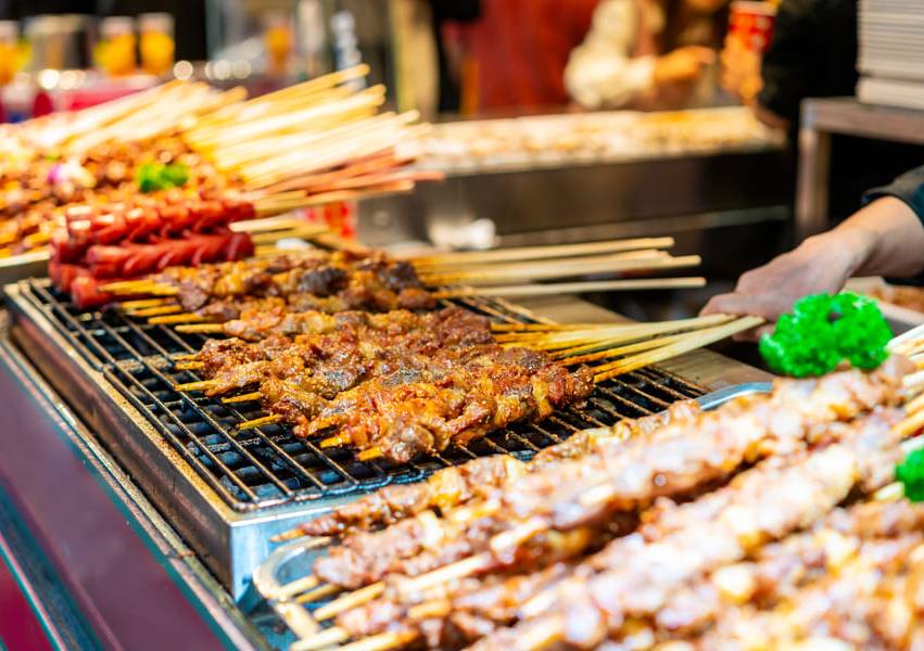 Trozos de carne insertados en un palillo en una parrilla