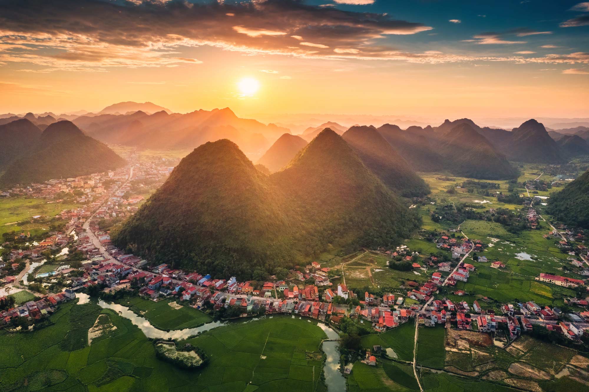 Una montaña rodeada de un pueblo al atardecer